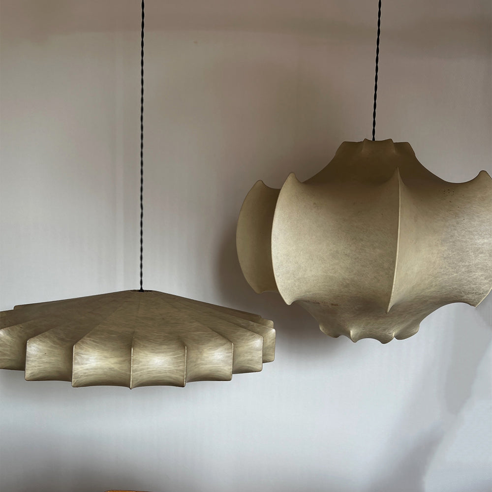 Lemieux et Cie Cheverny pendant lights with sculptural scalloped shades in warm finish, suspended in neutral corner room with soft daylight.