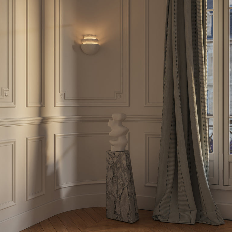 Lemieux et Cie Beaunay Tiered Sconce, a designer lighting fixture in cast plaster with layered bowl-shaped shades on a plaster wall in a European-style room with soft curtains.