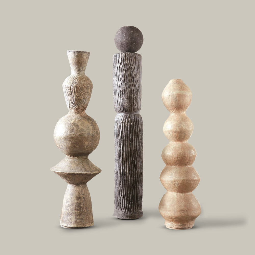 Lemieux et Cie Marcel Totem sculptural set, three turned forms with textured surfaces in warm and charcoal tones, shown on neutral studio backdrop.