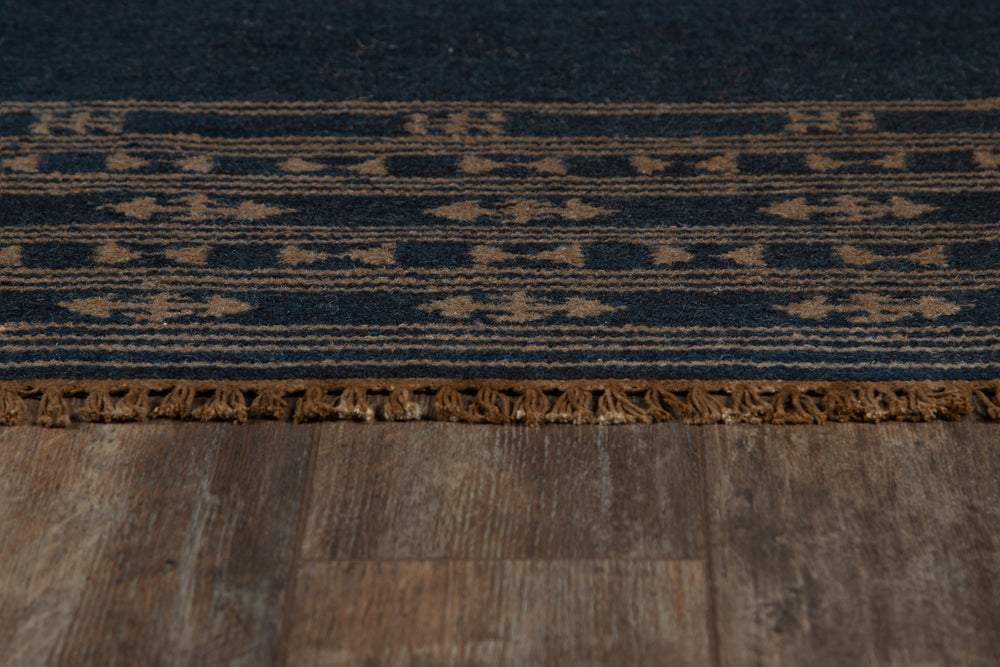 Lemieux et Cie Duar Rug in deep indigo with space-dyed striped pattern, handwoven rug edge detail shown on weathered wood flooring.