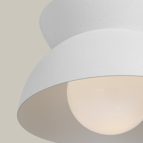 Lemieux et Cie Beaunay Medium Pendant, a luxury lighting fixture in steel, cast plaster, and milk glass from a low angle showing the lit bulb and textured plaster finish.
