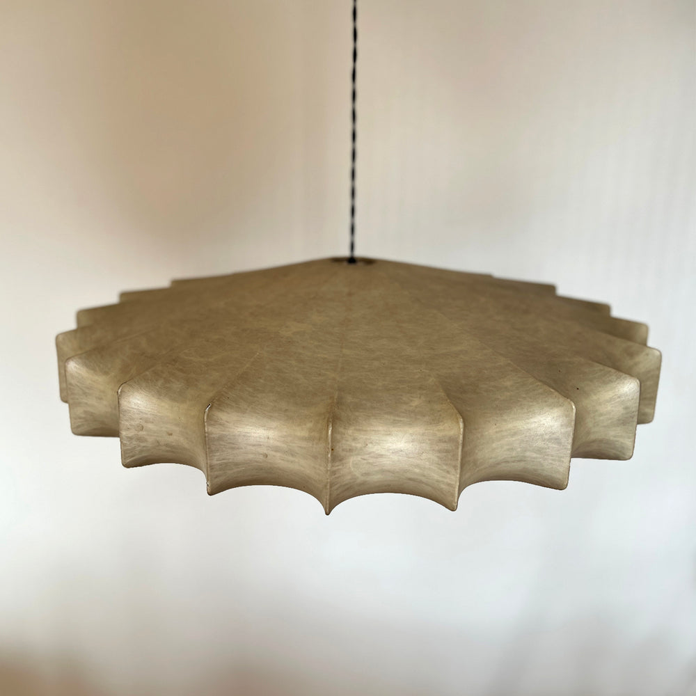 Lemieux et Cie Cheverny pendant light with scalloped-edge shade, sculptural chandelier suspended on slim cord against neutral studio backdrop.
