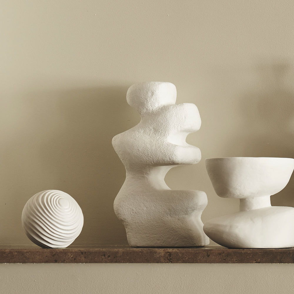 Lemieux et Cie Mouren Sculpture in white concrete with organic forms, displayed on wood shelf with neutral plaster walls and ceramic objects