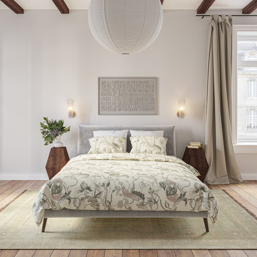 Lemieux et Cie Snake Floral Quilt Collection in white, taupe and gray cotton quilt, styled on upholstered bed in neutral bedroom with wood beams and soft daylight.
