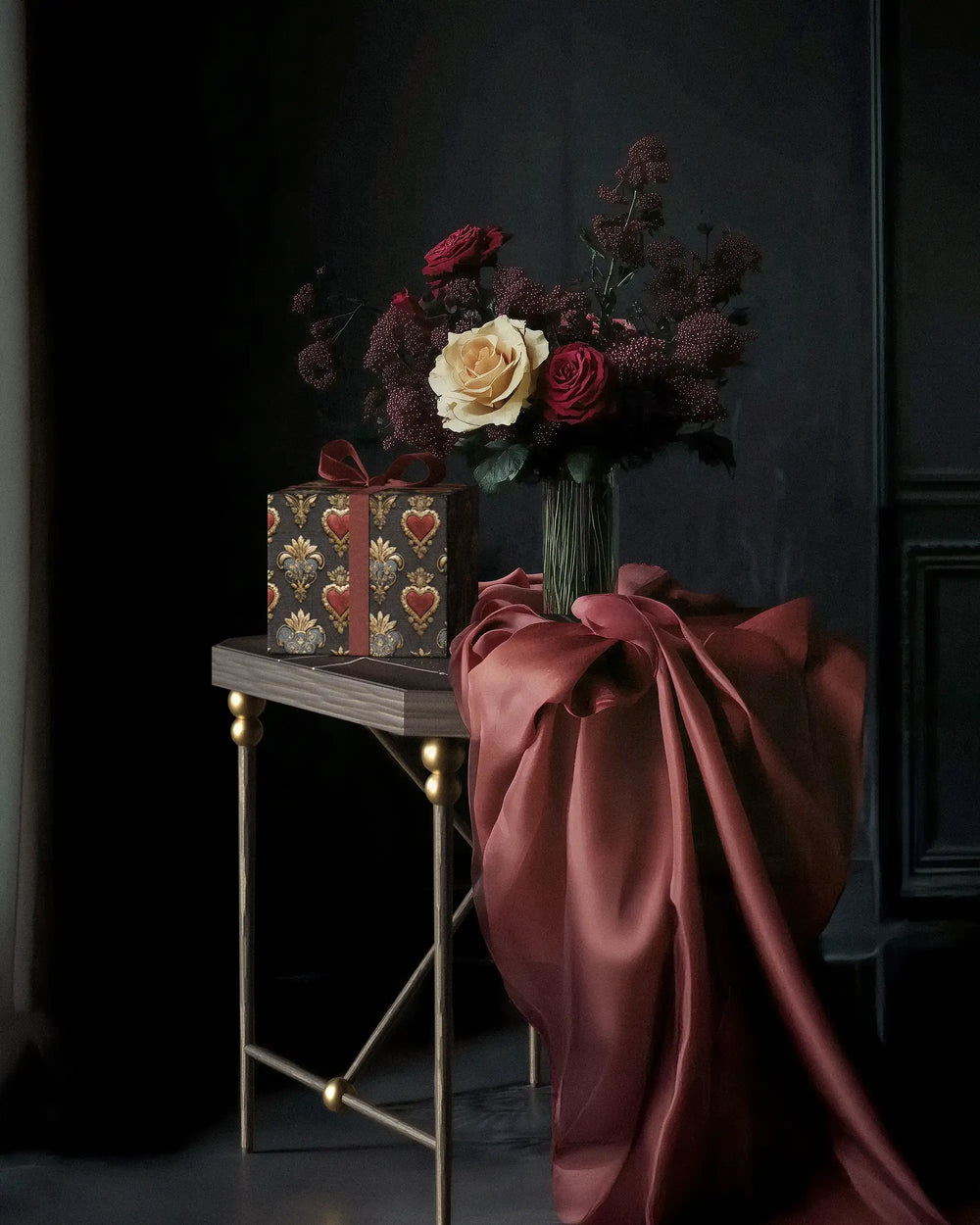 Lemieux et Cie Love Embroidery luxury gift wrapping paper Inspired by historic French embroidery in a moody room with a Cambert iron side table, a bouquet of roses and red satin fabric.