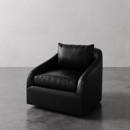 Lemieux et Cie Rousseau Swivel Chair in dark leather, sculptural low-profile silhouette with rounded arms, shown on concrete floor against white walls.