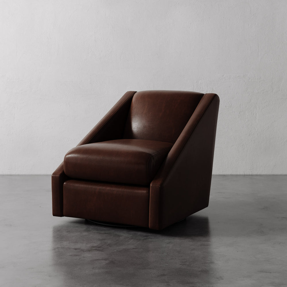 Lemieux et Cie Fontaine Swivel Chair in dark brown leather, sculptural angular silhouette, shown on polished concrete floor against white walls.