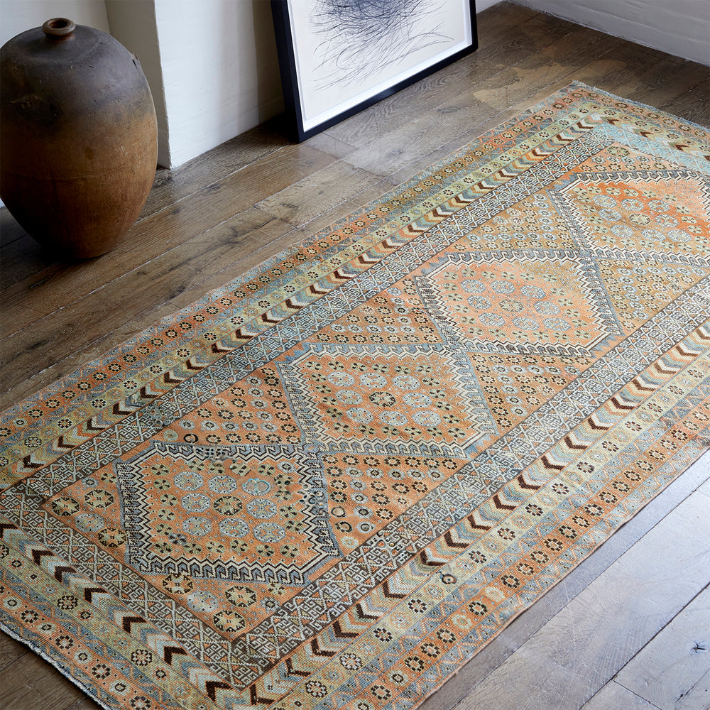 Lemieux et Cie Serab Rug in camel with geometric medallions, vintage Persian runner on light wood floors beside ceramic vessel and framed artwork.