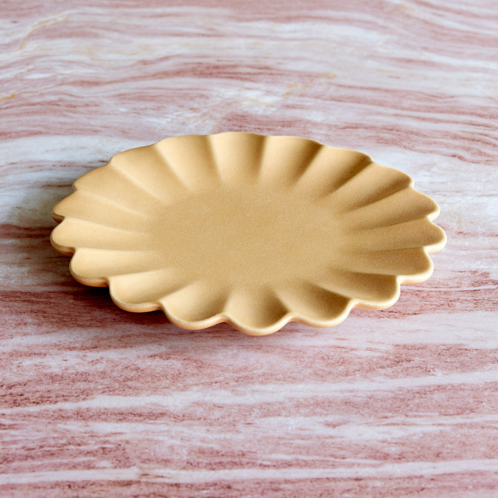 Lemieux et Cie Dhalia Stoneware Salad Plate in camel, scalloped ceramic plate with fluted edges on veined marble surface.