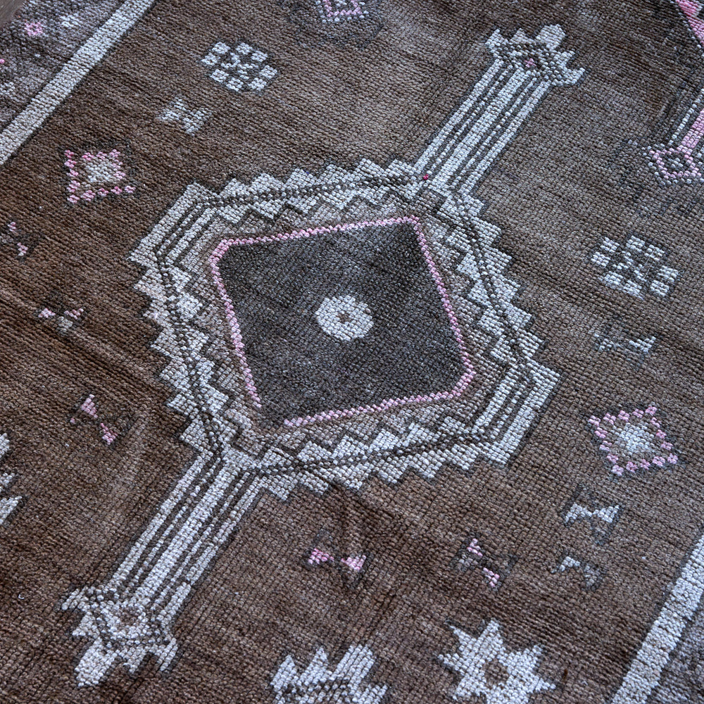 Lemieux et Cie Vintage 1960's Anatolian rug detail, woven geometric medallion pattern in gray, pink and charcoal on warm brown ground.