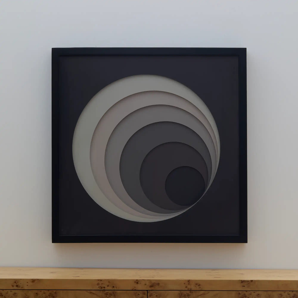 Lemieux et Cie Composition Tonale No. 4, framed concentric circular wall art in graduated grays, hung above wood console on white wall.