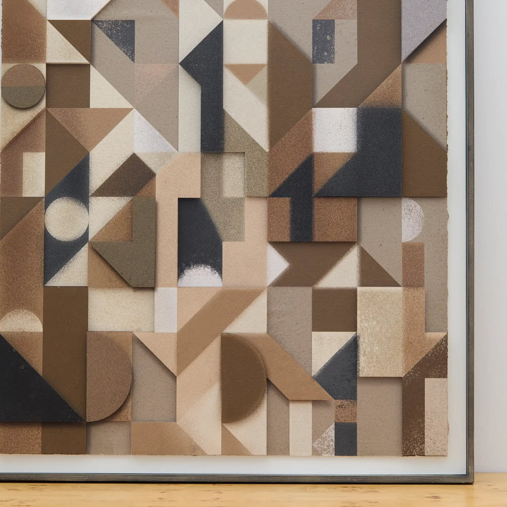 Lemieux et Cie Assemblage Géométrique No. 7, geometric wall art with layered shapes in warm neutrals and charcoal tones, shown on wood flooring.