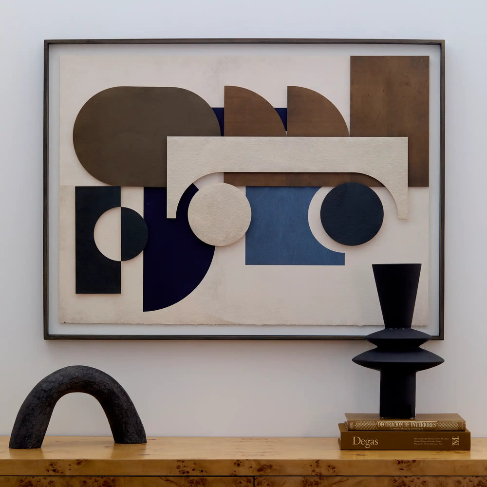 Lemieux et Cie Assemblage Géométrique No. 4, geometric abstract art in layered shapes and warm tones, framed above sculptural objects on wood surface.