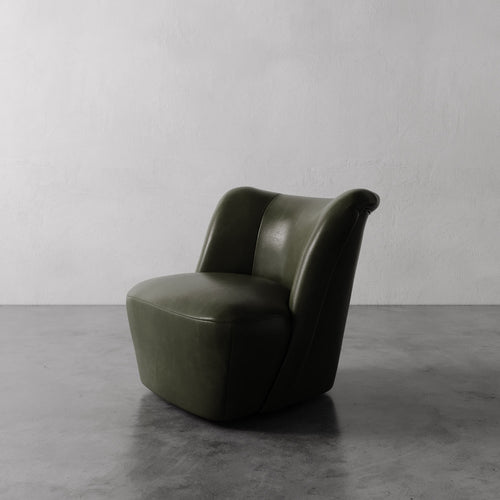 Lemieux et Cie Aurélie Leather Swivel Chair in olive green, sculptural rounded form on polished concrete floor against white plaster walls.