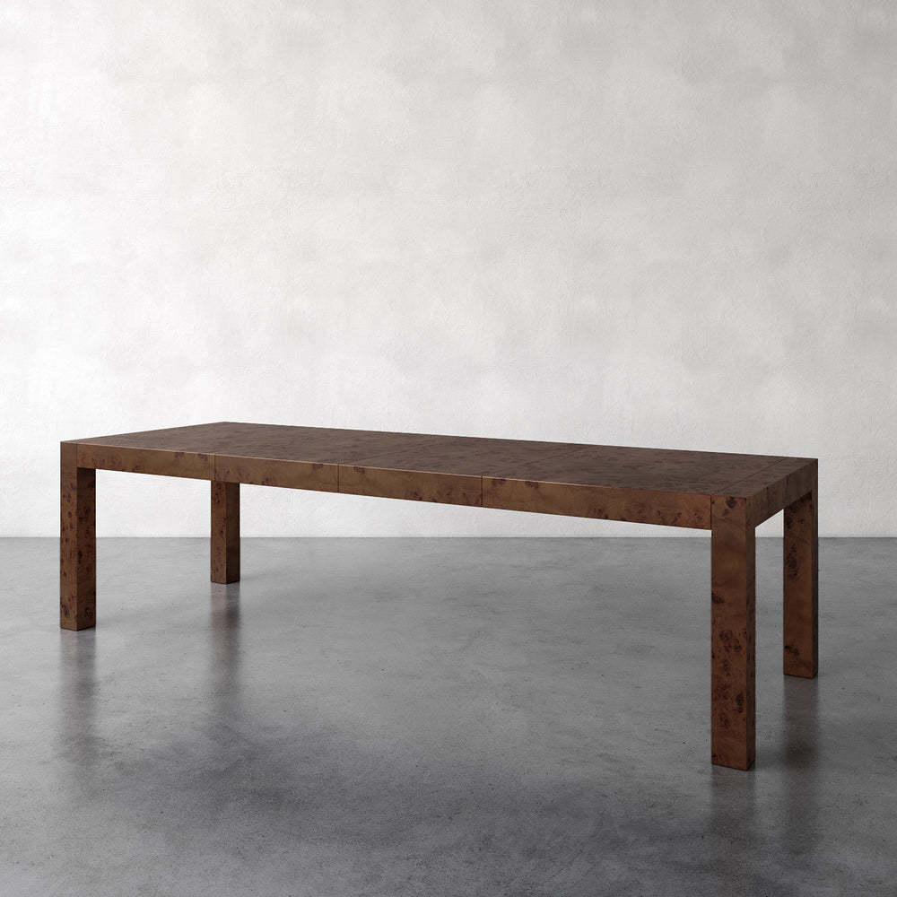 Lemieux et Cie Avenir Extension Dining Table in walnut burl, Parsons-style dining table with square legs on concrete floor against plaster walls.