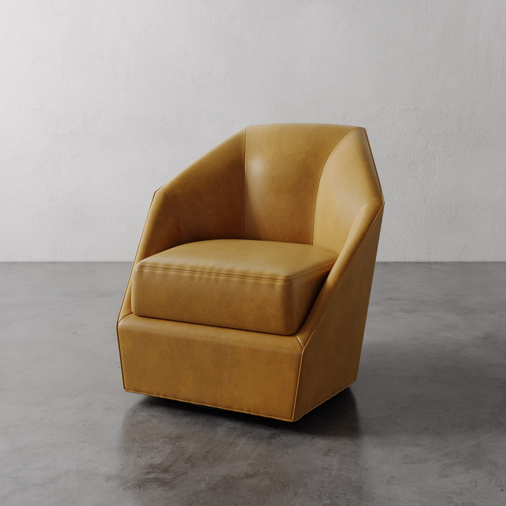 Lemieux et Cie Bijou Swivel Chair in warm tan leather, geometric low-profile lounge chair on polished concrete floor with white walls.