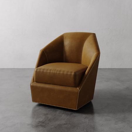 Lemieux et Cie Bijou Swivel Chair in warm caramel leather, geometric faceted form with enveloping back, shown on polished concrete floor.