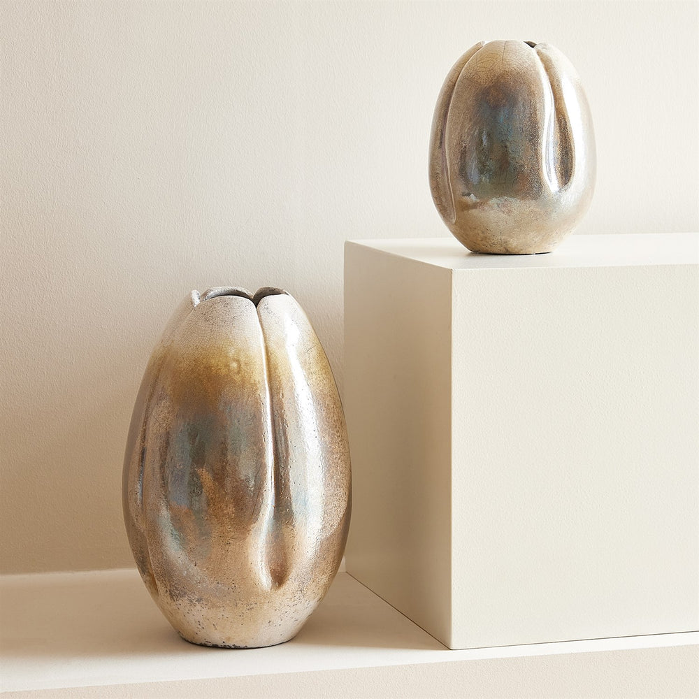 Lemieux et Cie Lafleur Vase, sculptural ceramic vessels in organic ribbed forms with warm tonal glaze, displayed on neutral pedestal against textured plaster wall.