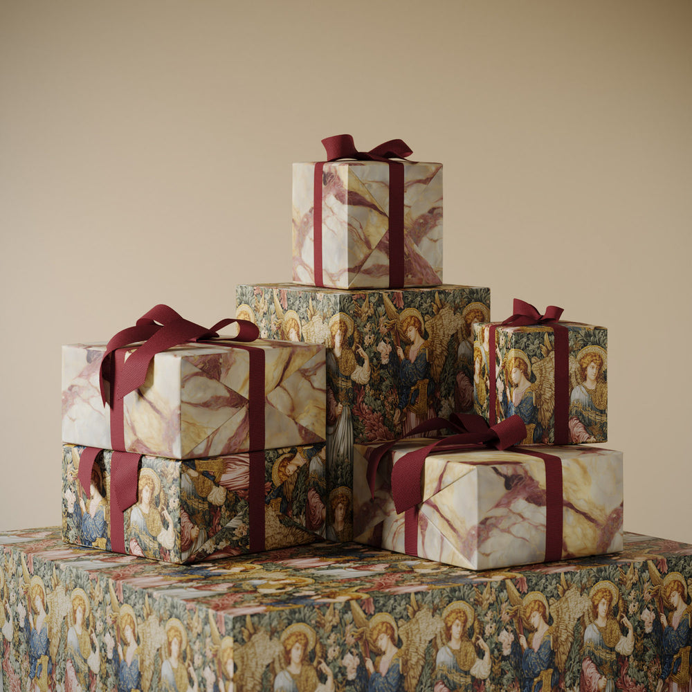 Gifts wrapped in Lemieux et Cie luxury Christmas wrapping paper featuring Angel's Jubilee Byzantine angels in gold and Rosa Aurora pink marble veining.