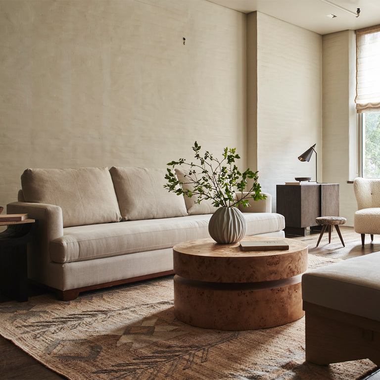 Lemieux et Cie Avenir Coffee Table, tiered circular coffee table in warm burl veneer, styled in a neutral sitting room with plaster walls and soft daylight.