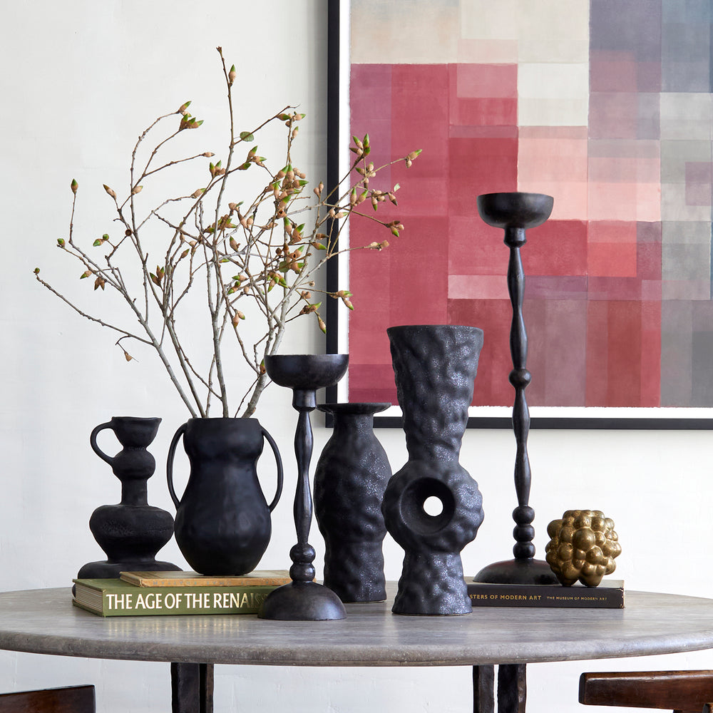 Lemieux et Cie Achille Candle Holder in dark finish, hand-forged sculptural candlestick with ornate beaded stem, styled on stone table with vases