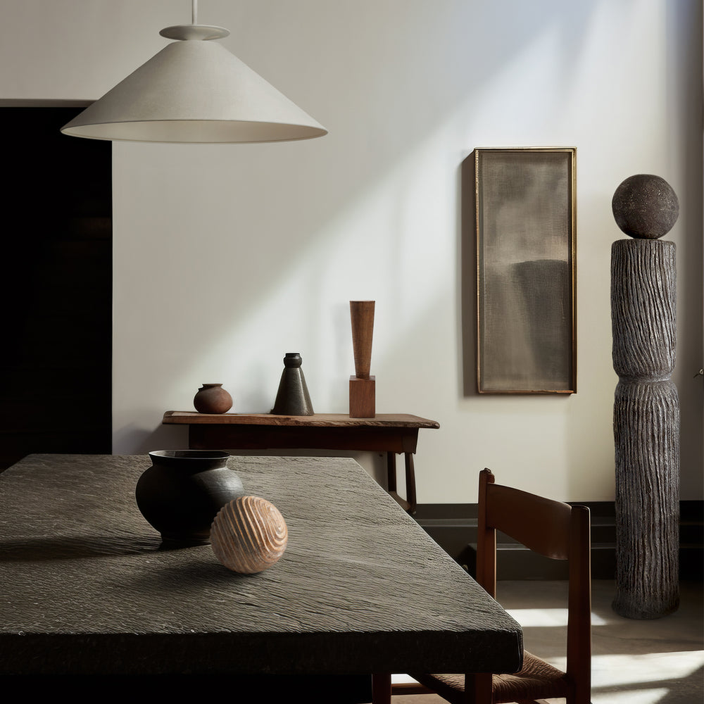 Lemieux et Cie Andre Totem sculptural ceramic form with textured surface and spherical top, shown in a dining room with warm daylight, neutral walls, and wood table.