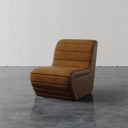 Lemieux et Cie Brunoy Leather Chair in warm tobacco leather with channeled upholstery, sculptural slipper chair on polished concrete floor.