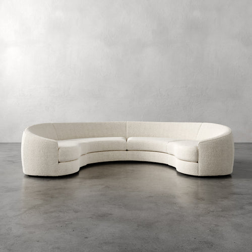 Lemieux Et Cie Rulmann 4-Piece Sectional  Curved beige sofa against a plain gray wall
