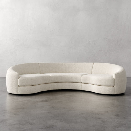 Lemieux Et Cie Rulmann Rulmann 3-Piece Sectional Curved beige sofa against a plain gray wall