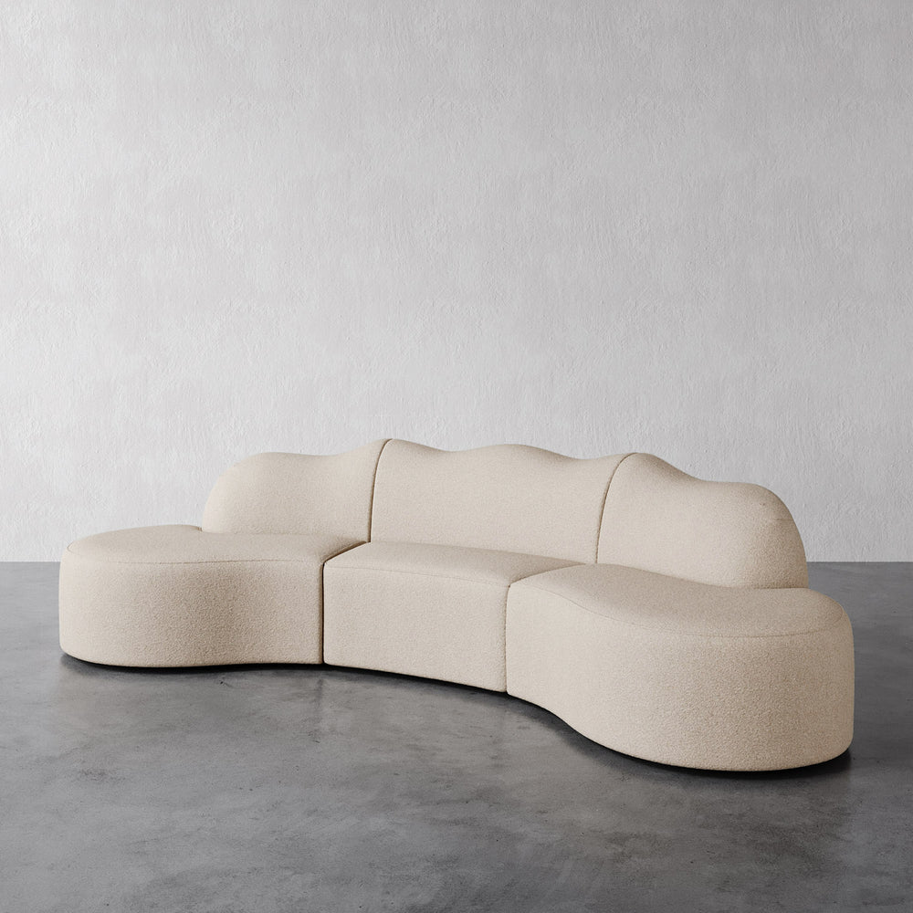 Lemieux Et Cie Serpentine 3-Piece Sectional Beige modular sofa on a gray floor with a plain white wall background