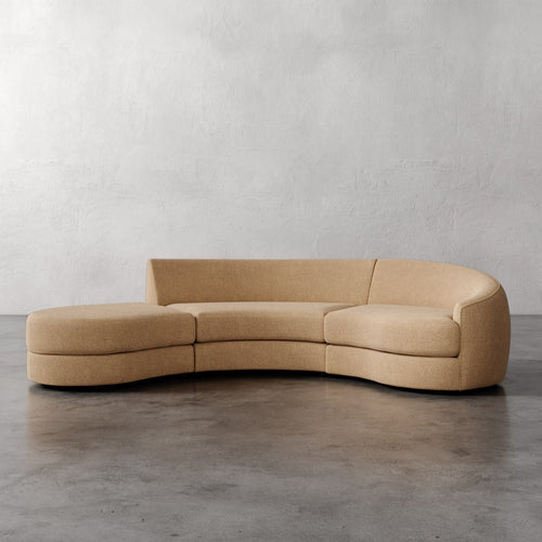 Lemieux Et Cie Rulmann 3-Piece Right Sectional  Beige curved sofa on a gray floor with a plain white wall background