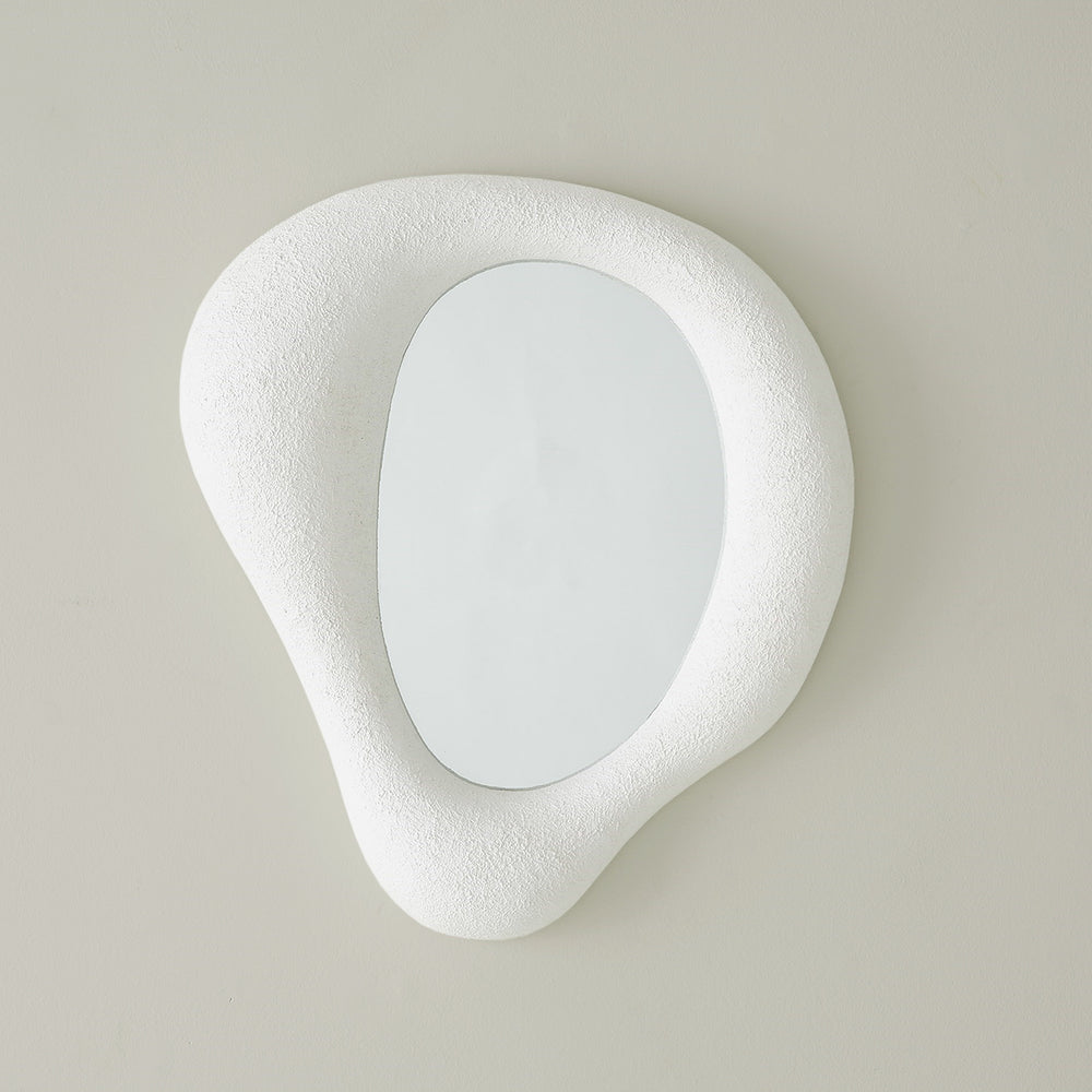 Lemieux et Cie hand-sculpted mirror with asymmetrical organic frame in white textured finish, hung against neutral grey wall.