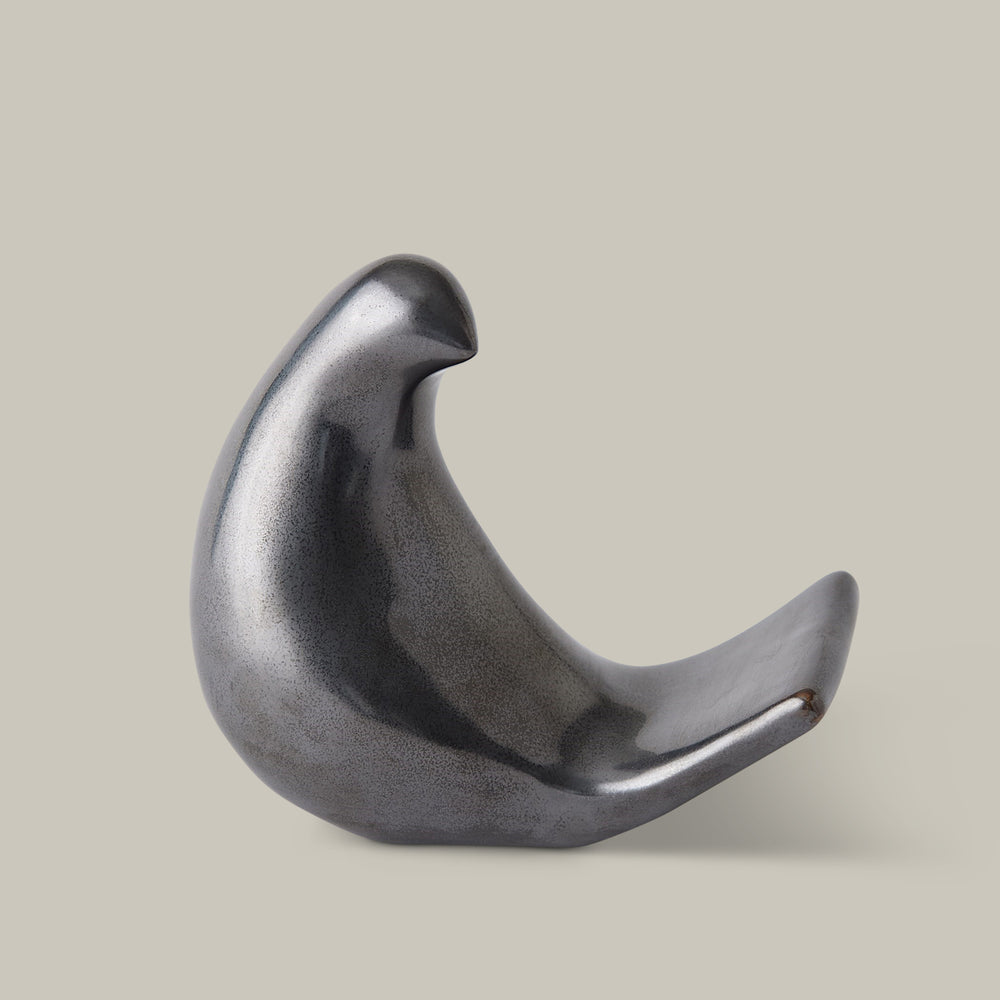 Lemieux et Cie sculptural bird object in dark gray, organic dove form on neutral studio backdrop