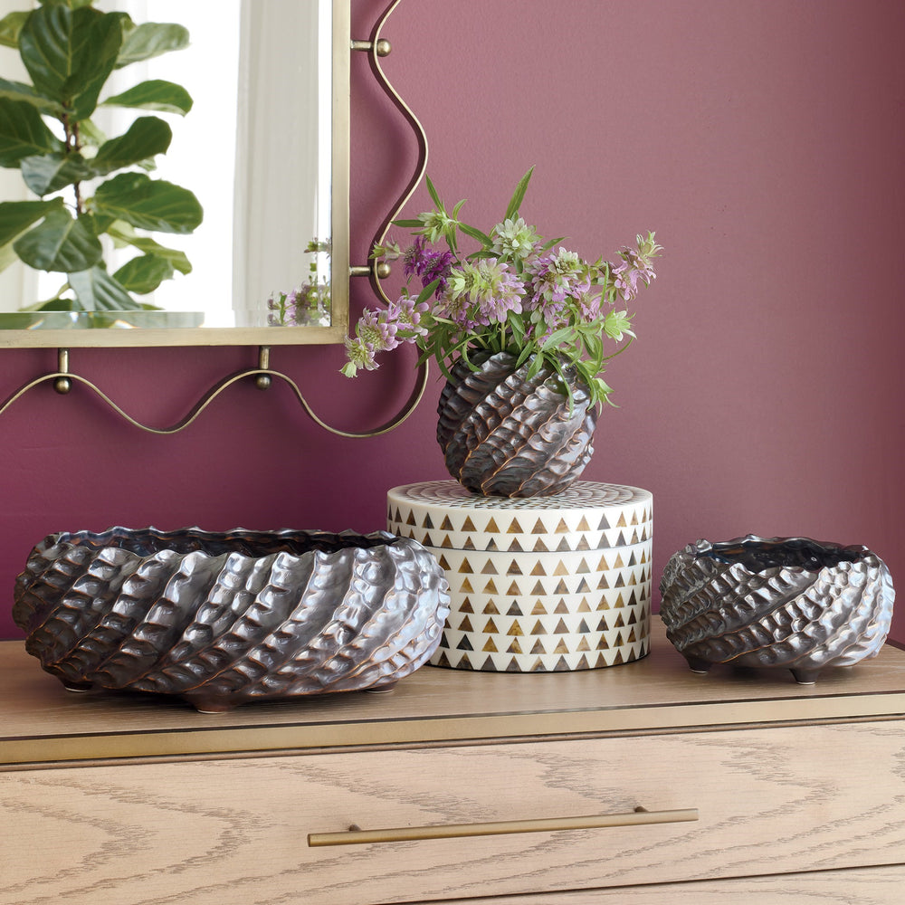 Lemieux et Cie handmade pinched clay bowls and vase in dark glaze, ceramic vessels styled on light wood shelf against mauve walls with mirror and florals
