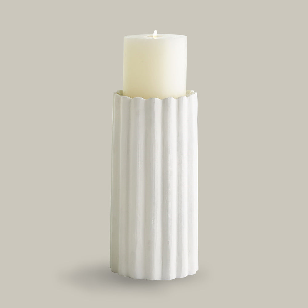 Lemieux et Cie Gaspard Vase in white with fluted columnar form holding an ivory pillar candle, shown on neutral studio backdrop.
