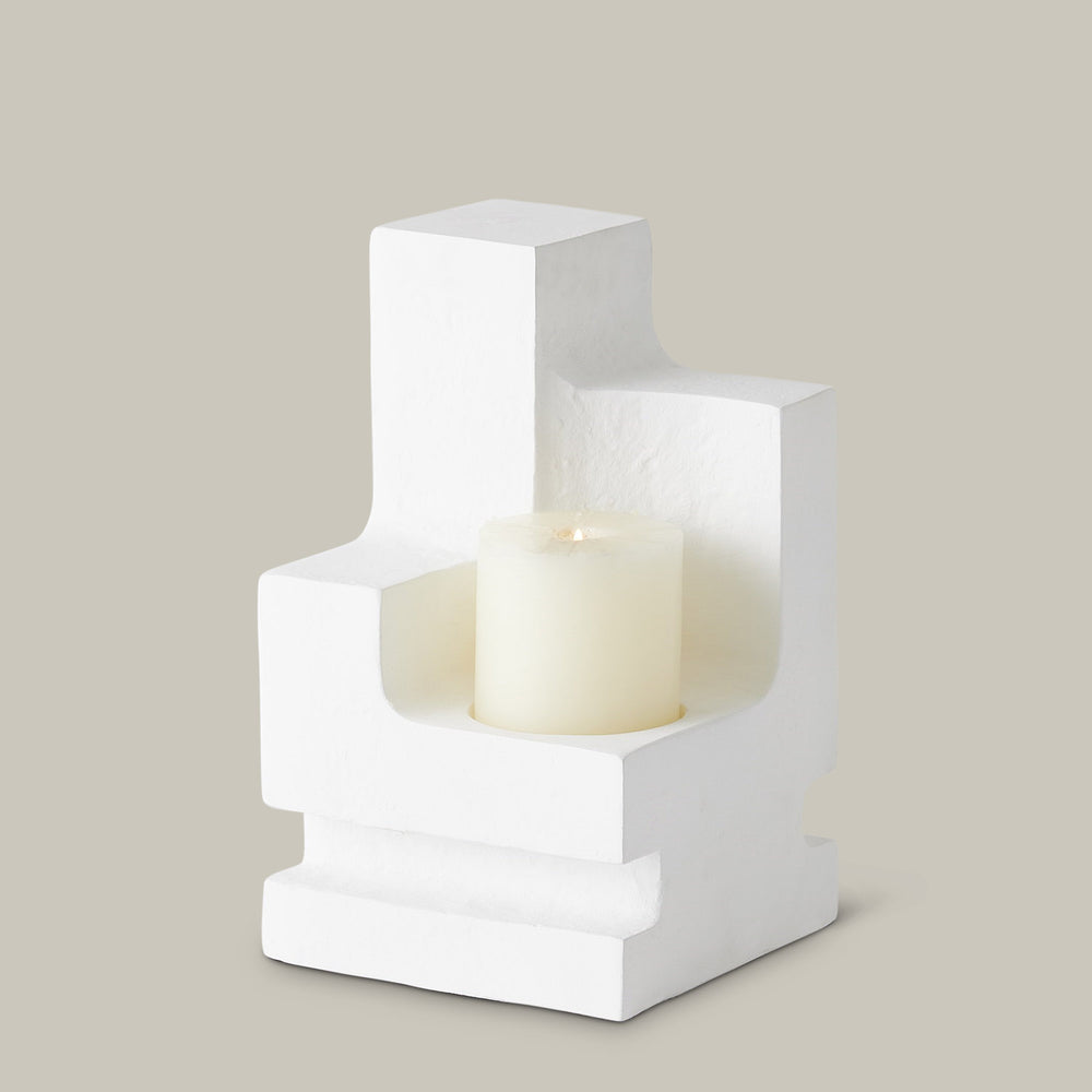 Lemieux et Cie La Structure Sculptural Pillar Holder in white, geometric candleholder with stepped form, shown on neutral backdrop with pillar candle.