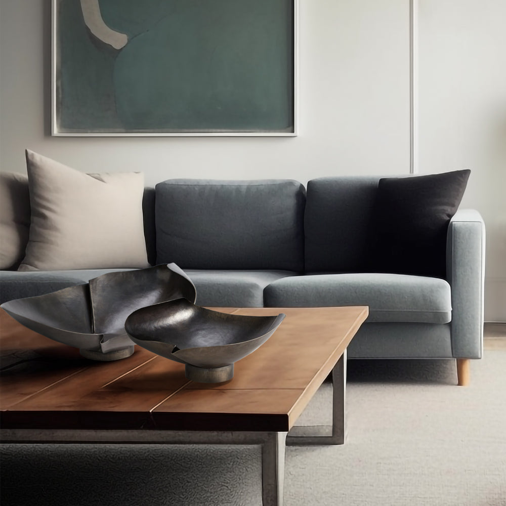 Lemieux et Cie tufted back sofa in grey upholstery with streamlined arms and shaped legs, styled in neutral sitting room with wood coffee table and abstract artwork.
