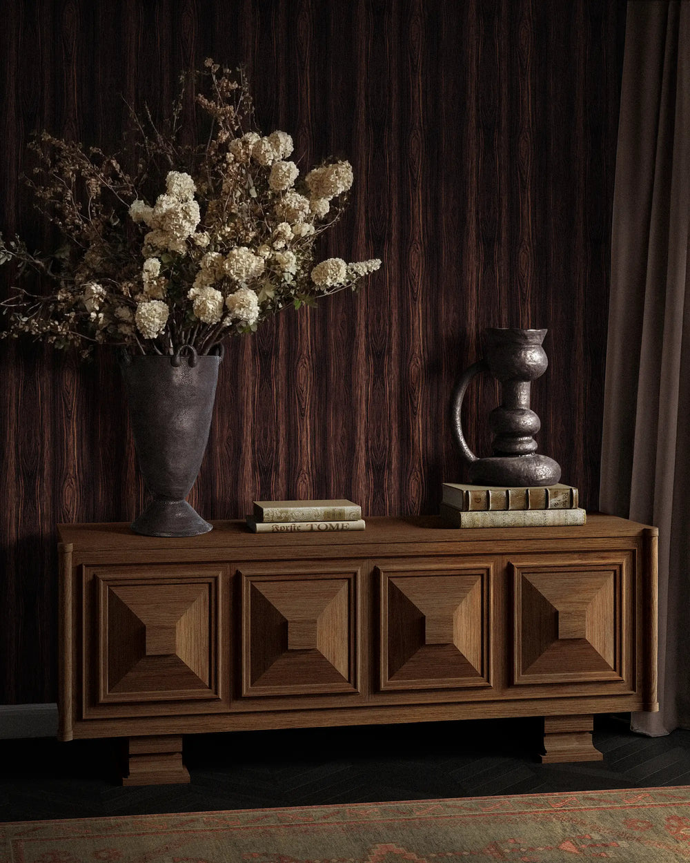 Lemieux et Cie Cabinet Palissandre sideboard with geometric paneled front on pedestal base, styled with dried florals and aged vessels against wood-paneled walls.
