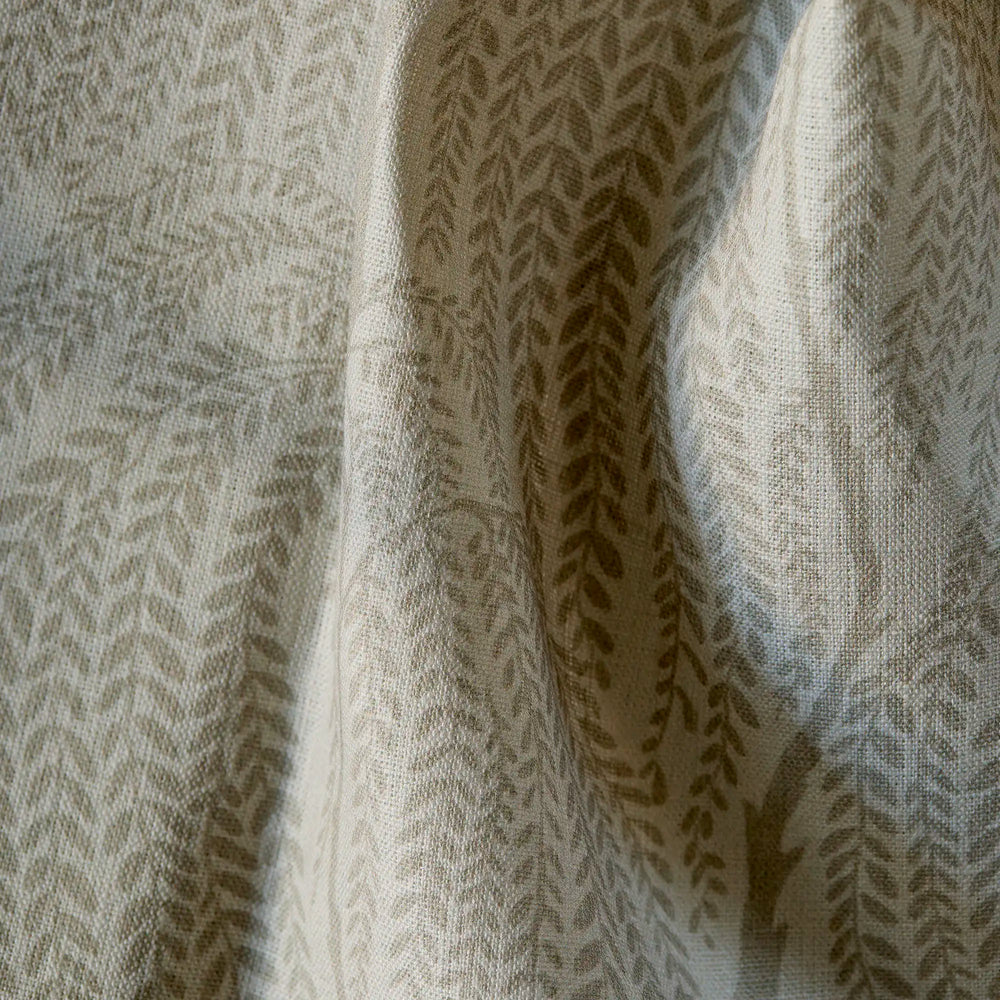 Close up of fabric with cascading willow botanical pattern in warm ivory, flax, and taupe on linen with natural slub texture
