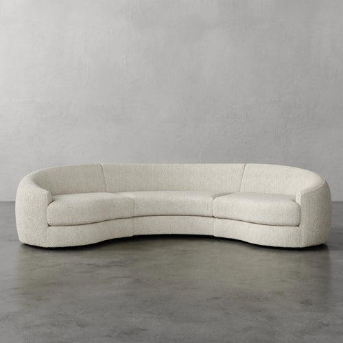 Lemieux Et Cie Rulmann Rulmann 3-Piece Sectional Curved beige sofa against a plain gray wall