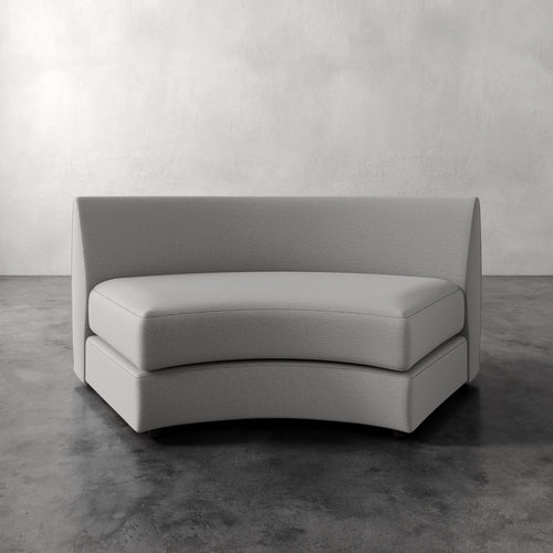 Lemieux Et Cie Rulmann Wedge Gray sofa on a concrete floor with a white wall background