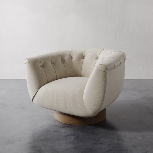 Chunky natural color Lemieux et Cie Lune Swivel Chair with a rounded tufted back and sculptural form set against a white wall.