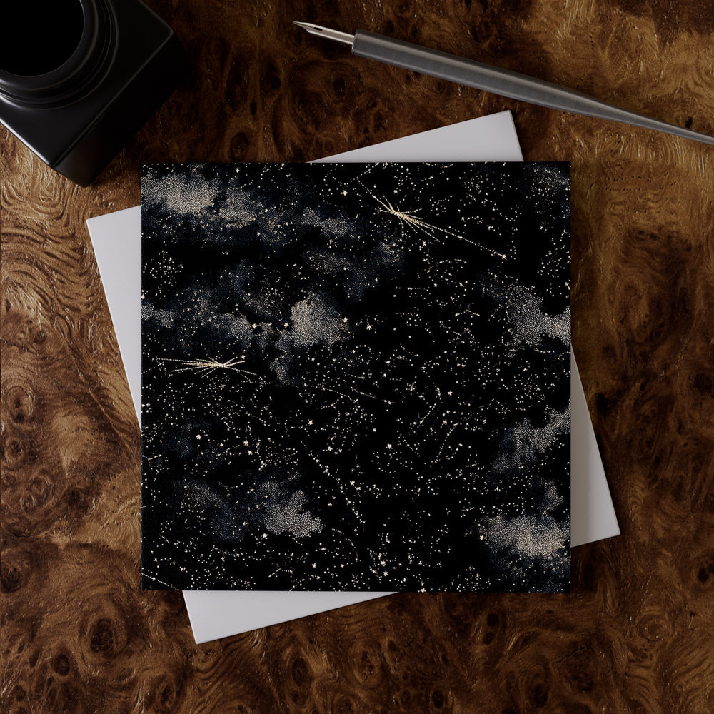 Lemieux et Cie Cosmos Greeting Card Set in black with celestial constellation pattern, shown on burl wood desk surface with white envelope and pen.