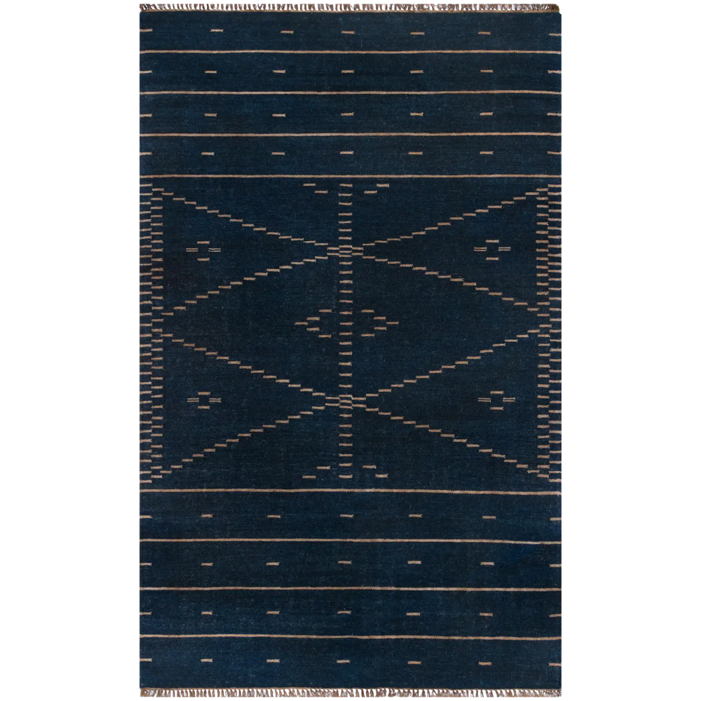 Lemieux et Cie Doukkala rug in deep indigo with tan geometric motifs, hand-knotted wool with hand-shorn pile, shown on white studio backdrop.