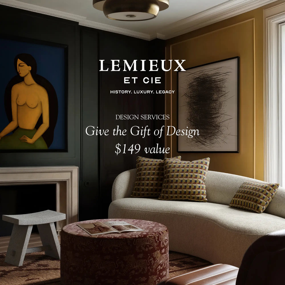 Lemieux et Cie Design Services gift card promotional image, curved sofa with geometric pillows in sitting room with dark and warm ochre walls, framed art, and warm overhead lighting.