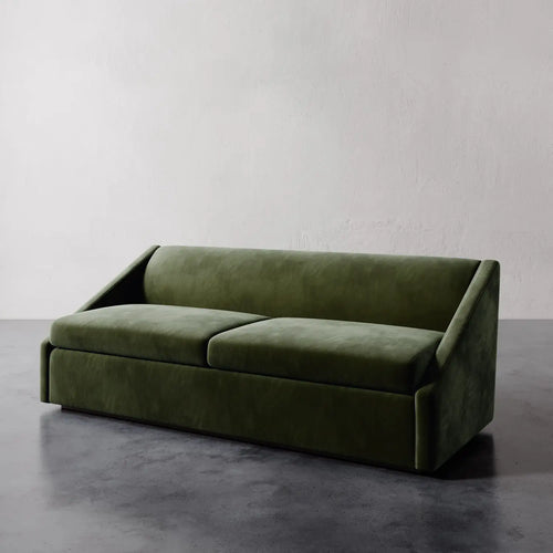 Lemieux et Cie Fontaine Sofa in olive green upholstery, low-profile sofa with angular arms, shown on polished concrete floor against white plaster wall.