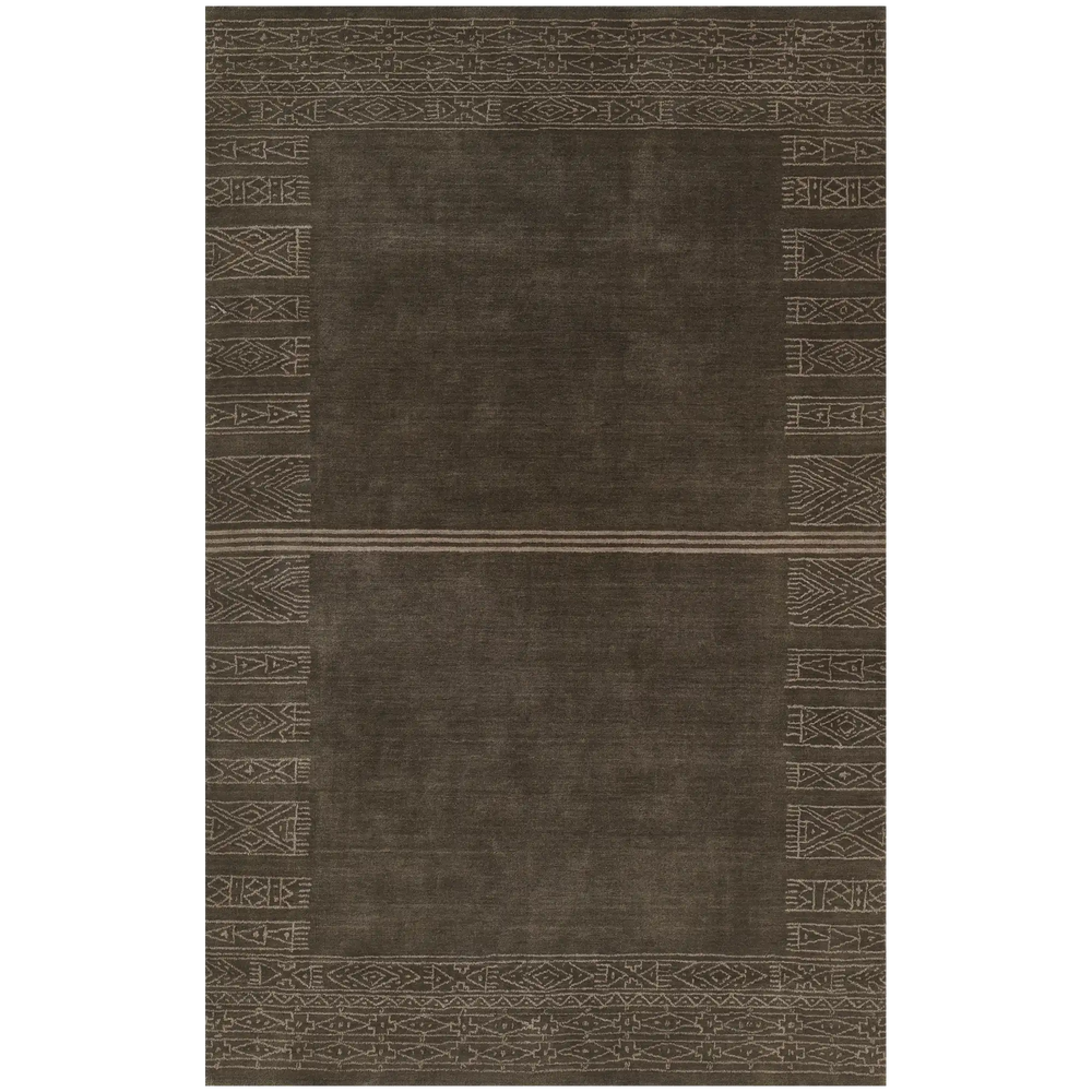 Lemieux et Cie handwoven rug in warm brown with geometric tribal border motifs, shown on white studio backdrop.