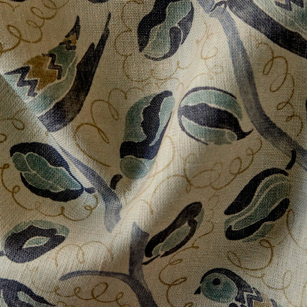 close up of Linen fabric with French bird and botanical pattern in indigo, teal, and hazelnut on natural flax ground