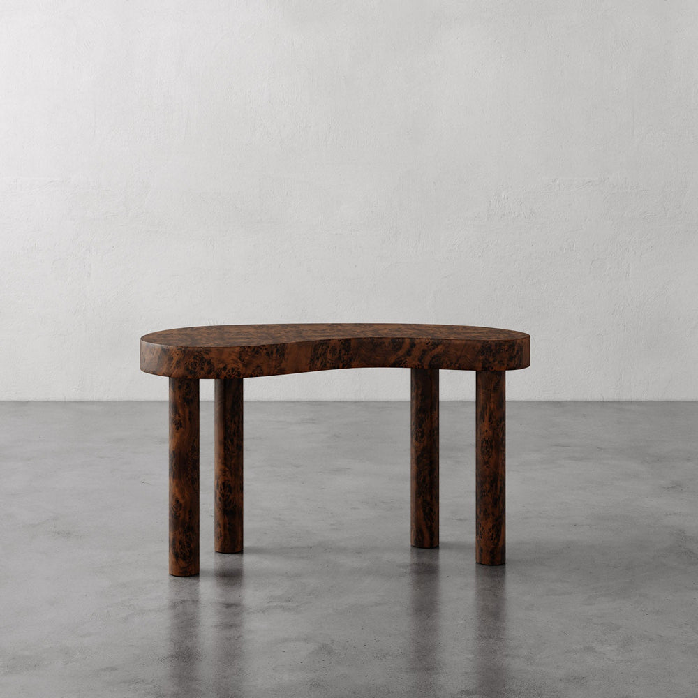 Lemieux et Cie Brenne Desk with organic shaped top and cylindrical legs, shown on polished concrete floor against neutral plaster walls.