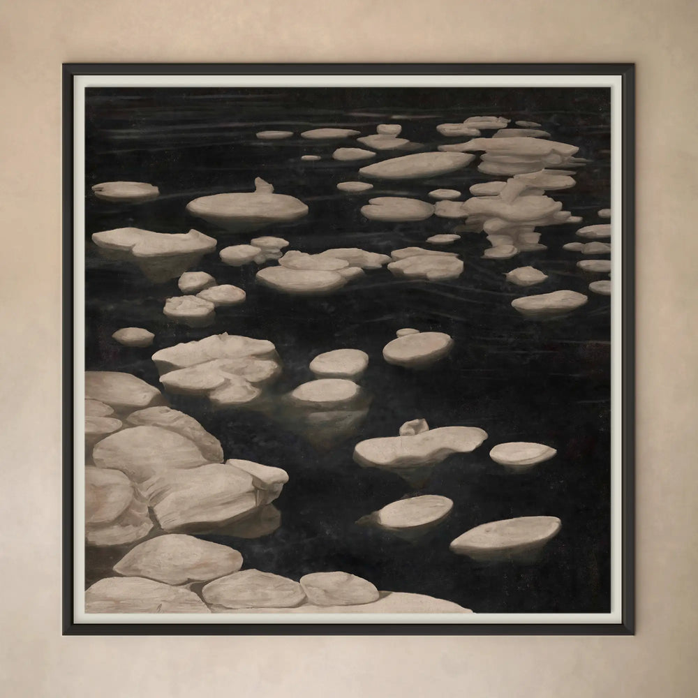 Lemieux et Cie Les Glaçons fine art print, monochromatic icebergs floating in dark water, framed in dark wood against neutral plaster wall.